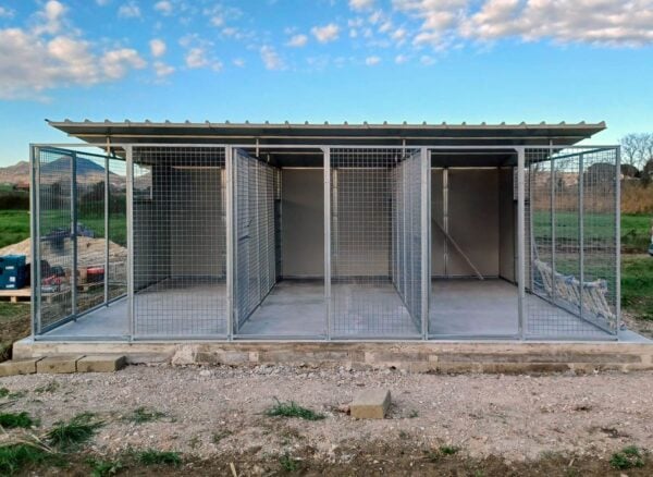 3 box in linea per cani, con tettoia. Su platea di cemento. Pannelli coibentati e rete metallica